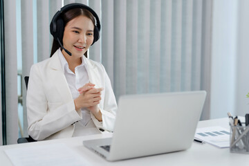 Smiling customer support service operator help desk. Young operator asian woman agent with headsets working support hotline in a call centre