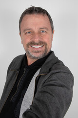 middle aged cheerful man on white background making phone selfie with camera smartphone in hand