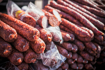 An outdoor stall with a bunch of homemade sausages for sale