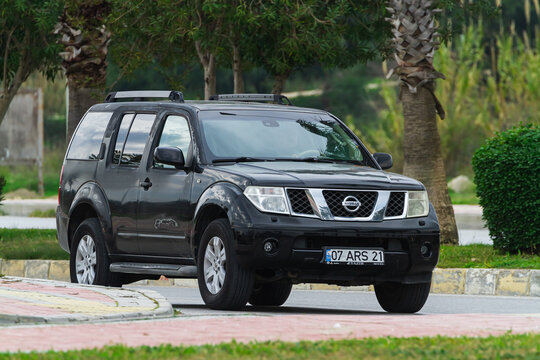 Side, Turkey -January 27, 2023:    black Nissan Pathfinder, driving   on the street on a  warm day