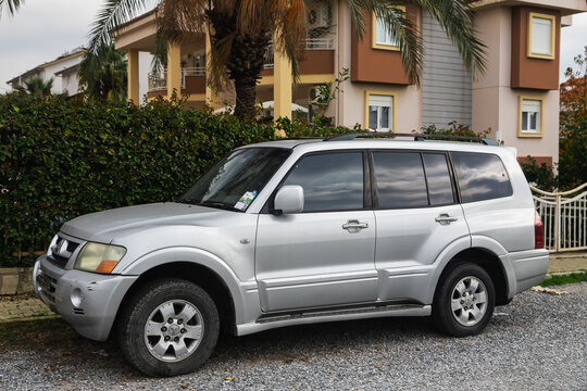 Side, Turkey -January 27, 2023:    silver Mitsubishi Pajero   is parked  on the street on a warm summer day against the  hose