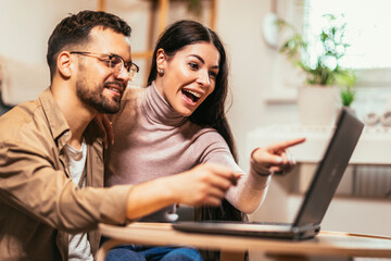 Young couple relaxing on sofa with laptop.Love,happiness,people and fun concept.