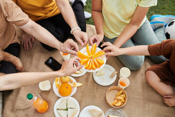 Family Members Taking Slices of Orange