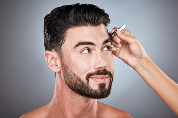 Face, barber and man with tweezers in studio isolated on a gray background for wellness. Thinking,...