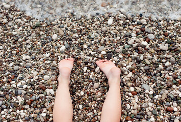 summer vacation, sunbathing and pedicure concept -child lying on the beach