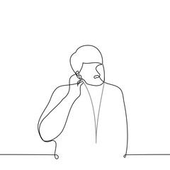 man inserting a wired earpiece into his ear - one line drawing vector. concept lover of wired headphones