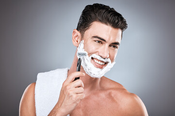 Shaving cream, face and man with razor in studio isolated on a gray background. Epilation, cleaning...