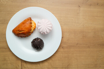 Assortment of delicious dessert. The concept of nutrition and unhealthy eating. Marshmallow, zephyr. Pastry. sweetness, sweet cake, dessert. Chocolate covered cookies on white plate