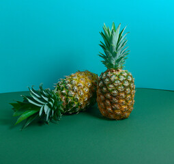 Stylish pineapples on a bright colored background, side view. A bright composition that attracts attention and lifts the mood. Poster design. Sweet couple, Relationship concept.