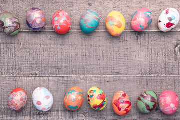 Composition de Pâques avec des œufs de poules colorés sur fond en bois avec de la paille....