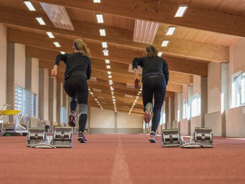 Two women running in athletics hall on tartan track, Offenburg, Baden-W&uuml;rttemberg, Germany