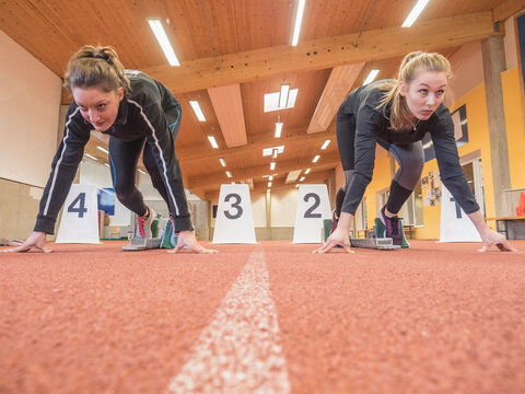 Two women runners on tartan track in starting position, Offenburg, Baden-W&uuml;rttemberg, Germany