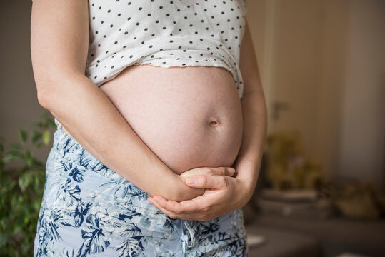 Midsection of a pregnant woman holding her belly, Munich, Bavaria, Germany