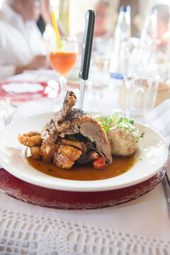 Roasted duck with bread dumpling on plate at restaurant table, Bavaria, Germany