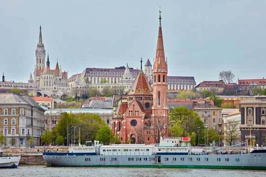 Matthias Church and Reformed church with docked ship on Danube river, Budapest, Hungary