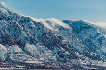 Rugged Utah mountains reflect in the bright snow.