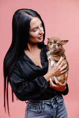Obraz premium Wonderful european female model chilling in studio with puppy. Indoor portrait of debonair girl enjoying photoshoot with her cute pet.
