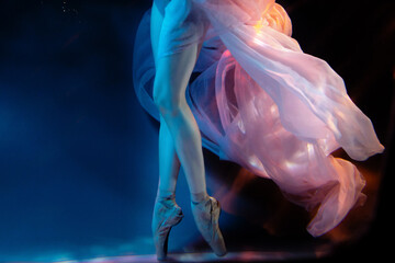 Ballerina, ballet dancer underwater. Legs in pointe shoes. Blurred soft focus - obrazy, fototapety, plakaty