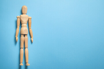 Wooden human figure on the blue background.