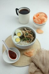 serve a bowl of chicken porridge with a cup of tea