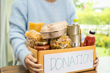 Volunteers putting various dry food in donation box for help people.