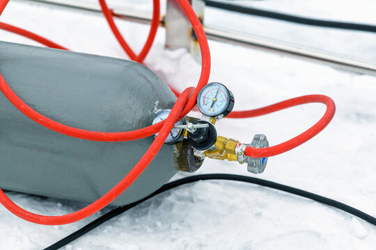 Close-up gas cylinder with a pressure gauge on the snow in winter for welding.