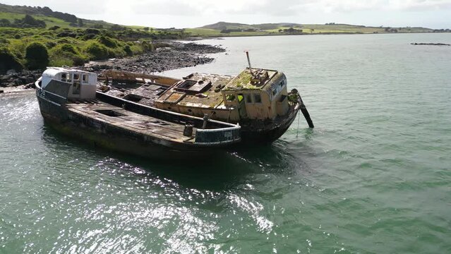 Aerial rotating view of an old and abandoned shipwreck on the coast of Bluff, New Zealand
