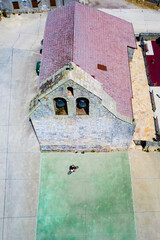 Little girl riding his bike through the village church square