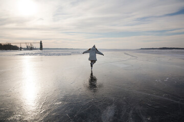 cheerful  woman  ice skating on a frozen river  in winter nature. Enjoying the little things....