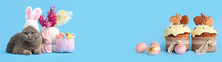 Delicious Easter cakes decorated with cookies and painted eggs on blue background
