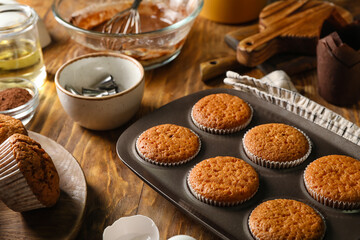 Tray with tasty muffins on wooden table, closeup