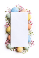 Easter composition of Easter quail eggs, flowers, paper blank over white background. Spring...
