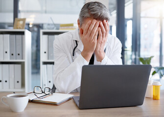 Doctor, burnout and man with stress in hospital feeling depressed while working on laptop. Mental health, depression and medical professional or physician with headache, pain and anxiety in clinic.