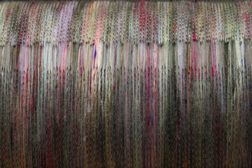 Closeup detail of  natural and colourful sheep wool fibres on a drum carding machine for making...