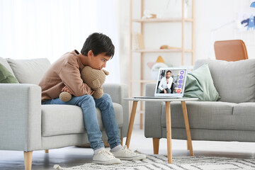 Little boy video chatting with psychologist at home