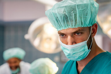 Portrait of a tired male surgeon at workin hospital. Healthcare pandemic people concept