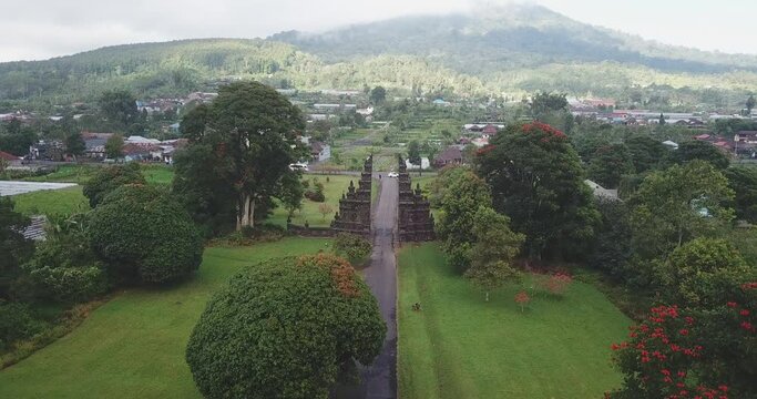 Drone shot of Candi Bentar split gates on roadside amidst trees in town