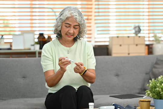 Diabetic Senior Lady Taking Blood Sample With Lancet Pen. Diabetes And Elderly Healthcare Concept