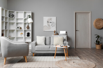Cozy interior of living room with grey sofa, armchair and painting