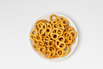Salted crackers or pretzels on white plate isolated on a white background top view