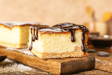 Board with pieces of cottage cheese casserole on wooden table, closeup