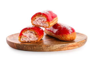 Wooden board with halves of delicious eclairs isolated on white background