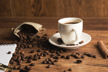 Cup of coffee, notebook and coffee beans