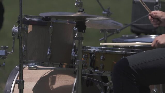 Close up on a drummer playing rock outdoor, wild festival