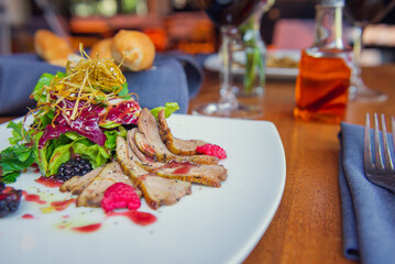 Roast duck breast with vegetables and fruits in restaurant