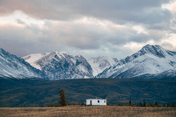 Round yurt is against the background of snow-capped mountains