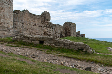 Fototapeta na wymiar The ruined outer walls/defences of Dunstanburgh Castle, on the Northumberland coast, UK