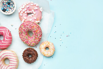 Parchment with different delicious donuts on blue background
