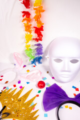 Carnaval costume party items still life with head accessories and color confetti on white background