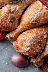 chicken drumsticks with spices, paprika and sesame seeds, ready to bake on a baking sheet